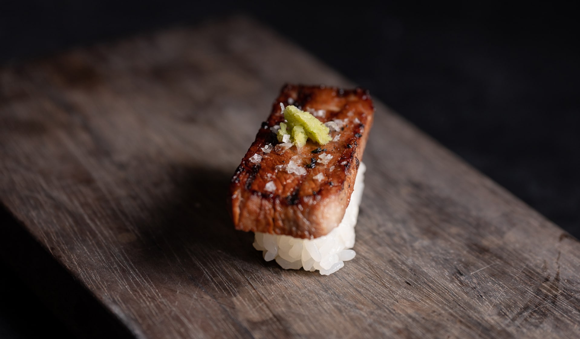 Gyutoro Nigiri served on a wooden plate.