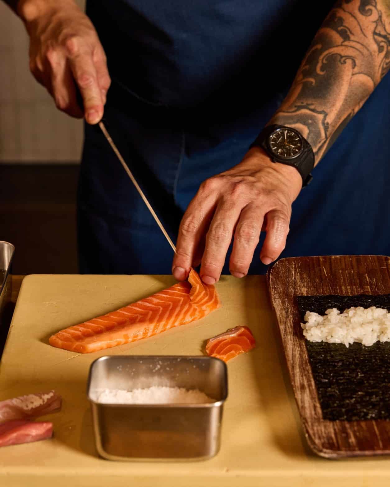 sushi chef making maki roll at uchi