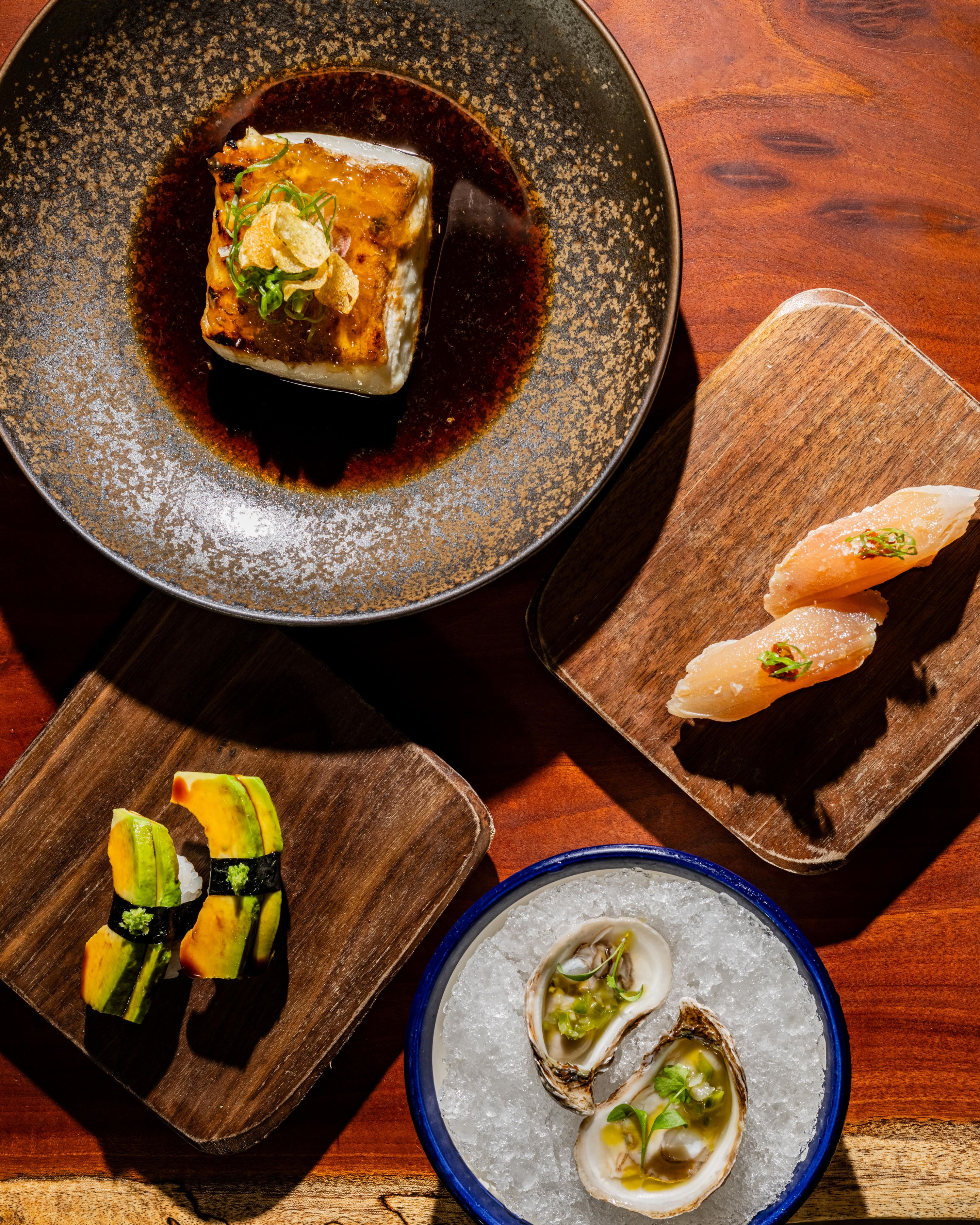 oysters, nigiri, and walu walu plated for happy hour